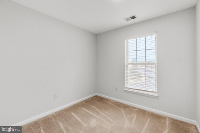 carpeted spare room featuring visible vents and baseboards