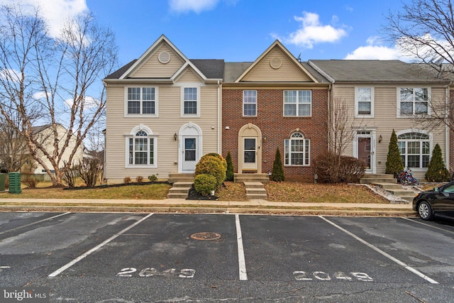 multi unit property featuring uncovered parking and brick siding