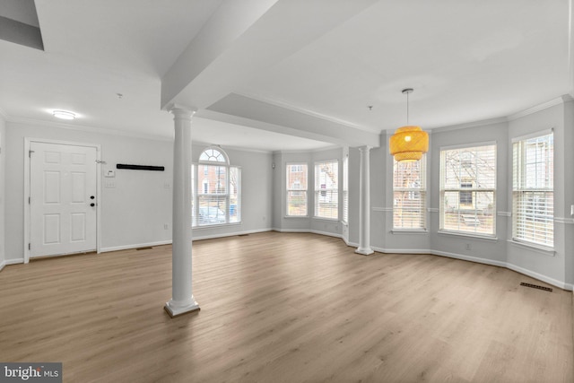 unfurnished living room featuring visible vents, baseboards, light wood finished floors, decorative columns, and crown molding