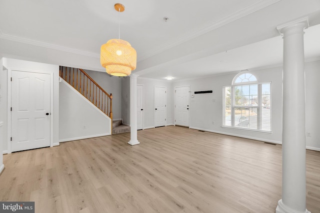 foyer entrance featuring ornate columns, light wood-style flooring, stairway, and crown molding