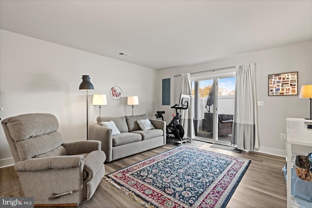 living area featuring wood finished floors, visible vents, and baseboards