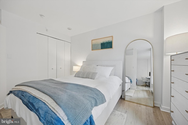 bedroom featuring baseboards, a closet, and light wood-style floors