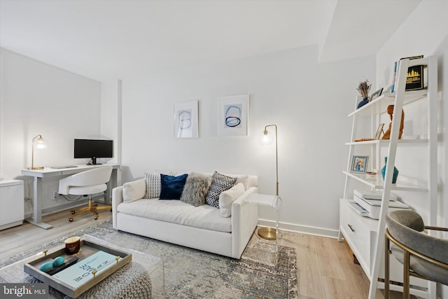 living area featuring baseboards and wood finished floors