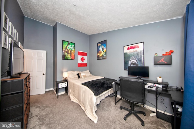 carpeted bedroom with a textured ceiling and baseboards