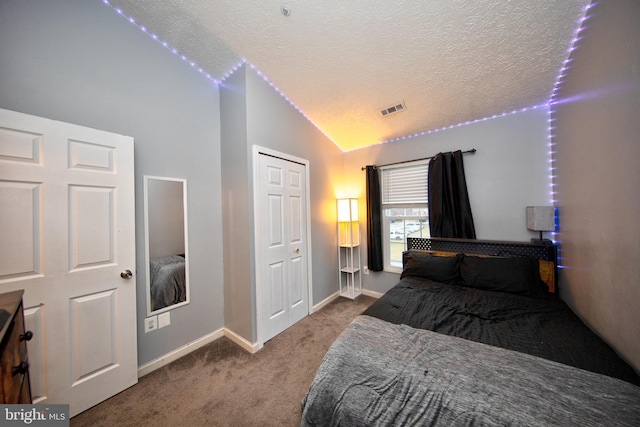 carpeted bedroom with baseboards, visible vents, lofted ceiling, a textured ceiling, and a closet