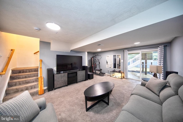 carpeted living area with a textured ceiling, stairway, visible vents, and baseboards