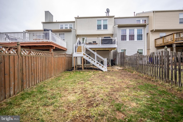 back of property featuring a yard, a fenced backyard, stairs, and a wooden deck