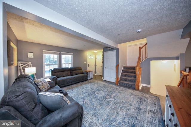 living area featuring wood finished floors, a textured ceiling, and stairs