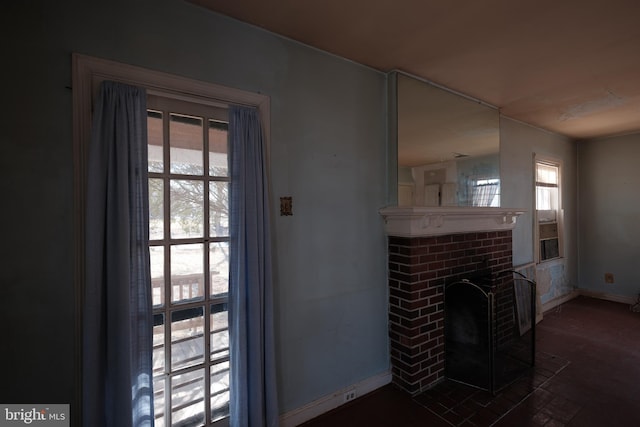 living area featuring a fireplace and baseboards