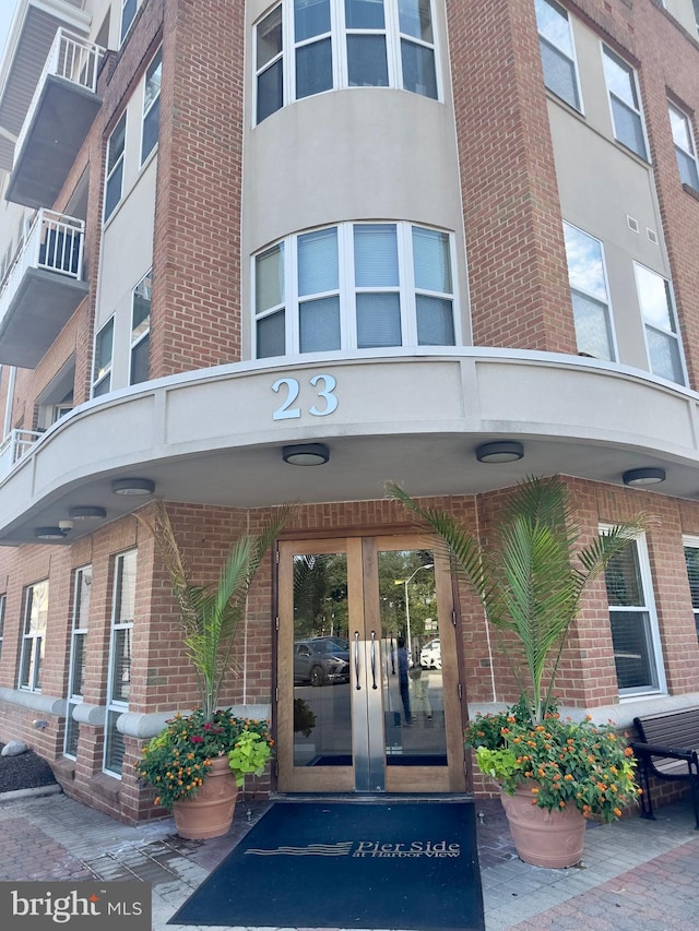 entrance to property featuring french doors and brick siding