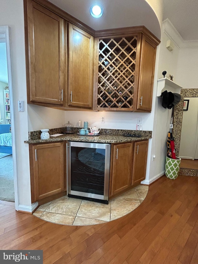 bar featuring wine cooler, ornamental molding, a bar, light wood-style floors, and recessed lighting