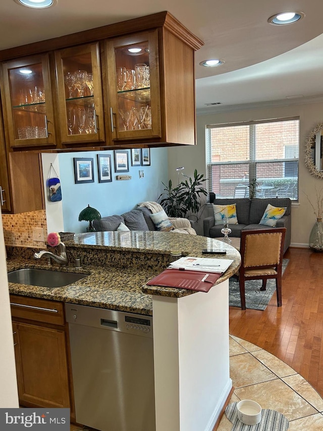 interior space with decorative backsplash, light tile patterned flooring, stainless steel dishwasher, a sink, and recessed lighting