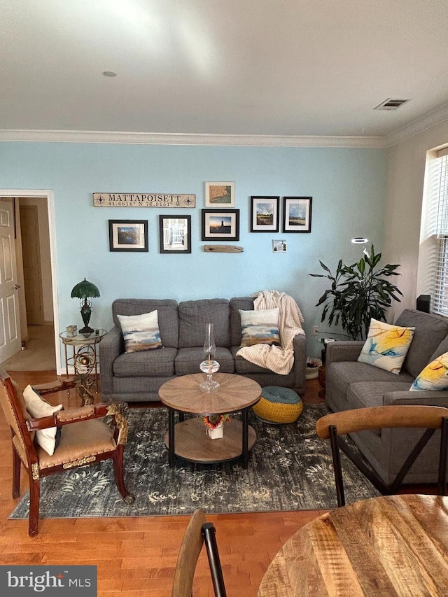 living room featuring ornamental molding, wood finished floors, and visible vents