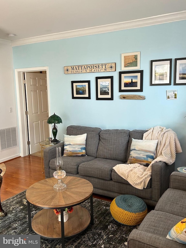 living room featuring visible vents, crown molding, and wood finished floors