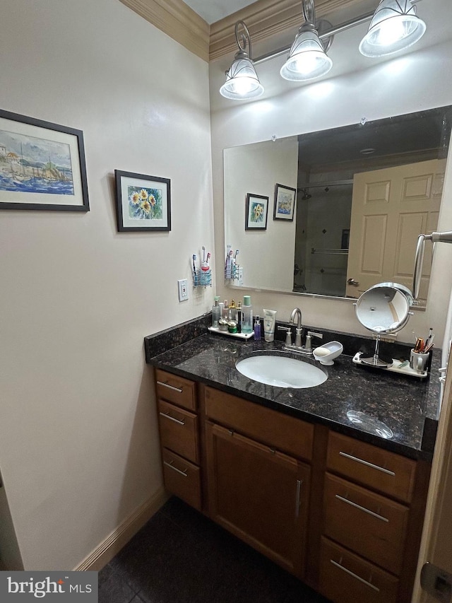 bathroom featuring baseboards, vanity, a shower with shower door, and tile patterned floors