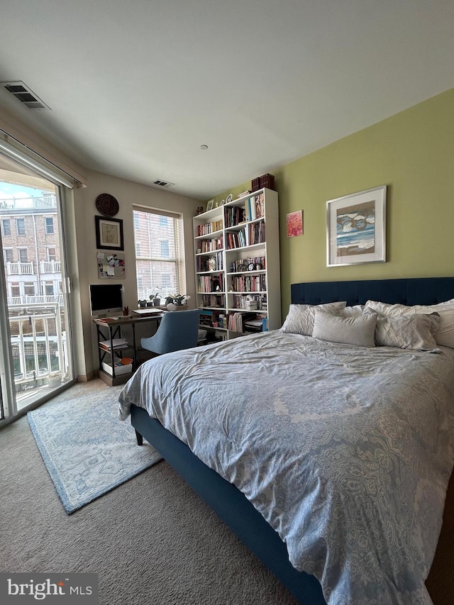 bedroom featuring carpet floors, visible vents, and access to exterior