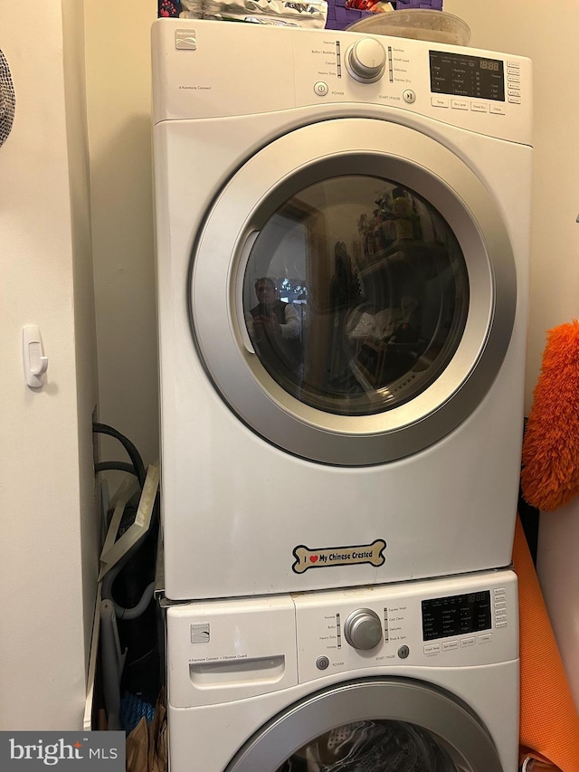 clothes washing area with laundry area and stacked washer / dryer