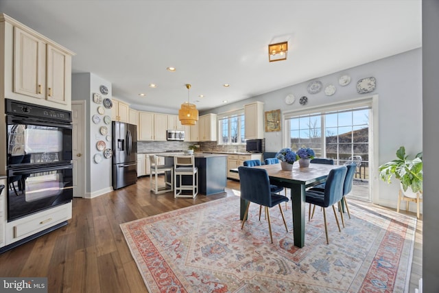 dining room featuring dark wood-style flooring, recessed lighting, and baseboards