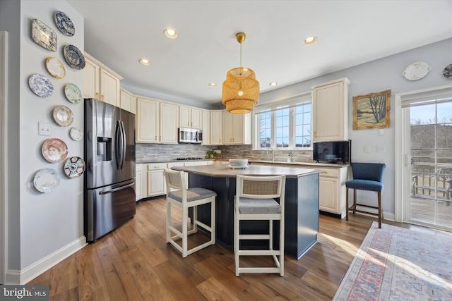 kitchen featuring appliances with stainless steel finishes, backsplash, and cream cabinetry