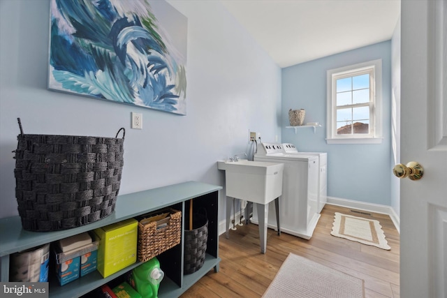 laundry room featuring laundry area, independent washer and dryer, baseboards, and wood finished floors