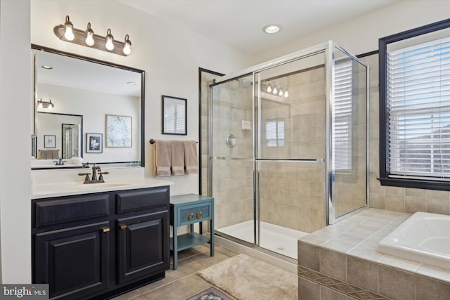 bathroom featuring a stall shower, vanity, a bath, and tile patterned floors