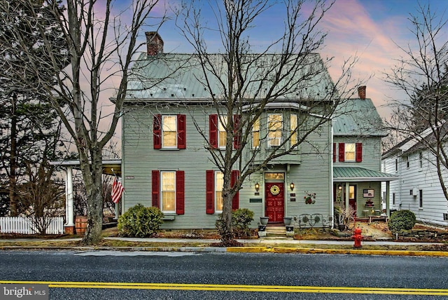 view of front of property featuring a chimney and fence