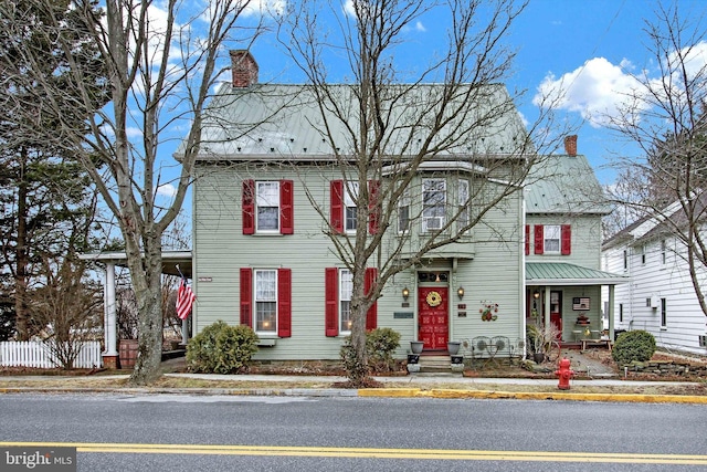 view of front of property with a chimney and fence