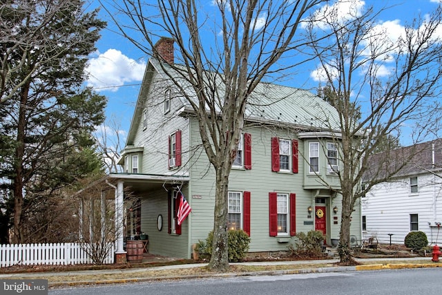 view of front of home featuring a chimney and fence