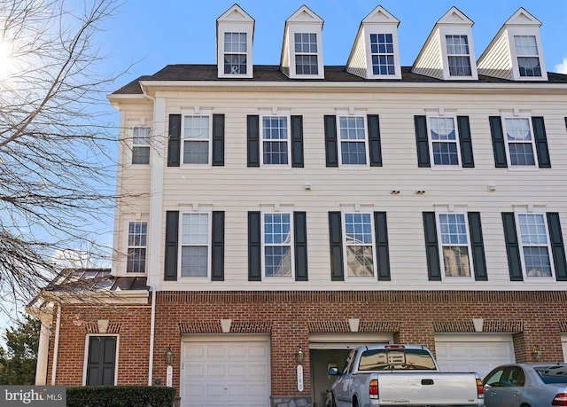 view of front of property featuring an attached garage and brick siding