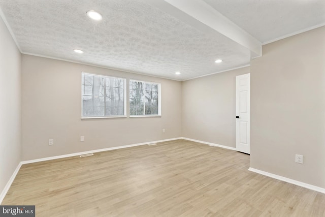 empty room featuring crown molding, baseboards, recessed lighting, light wood-style floors, and a textured ceiling