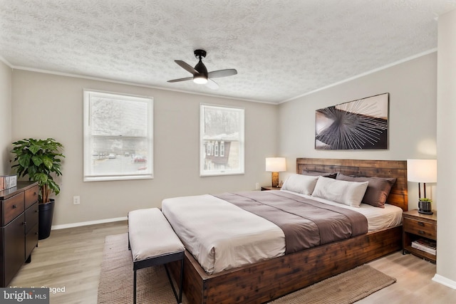 bedroom with a textured ceiling, light wood-style flooring, and ornamental molding