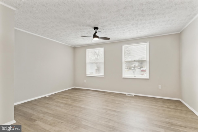 unfurnished room featuring crown molding, light wood-style flooring, a ceiling fan, and baseboards