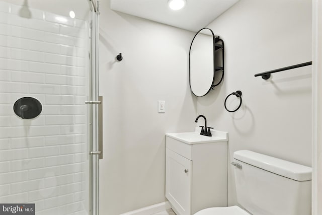 bathroom featuring a stall shower, toilet, vanity, and baseboards