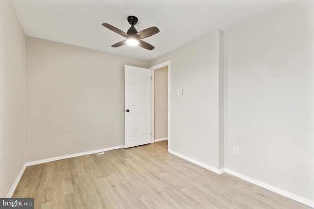 unfurnished room featuring baseboards, light wood-style flooring, and a ceiling fan