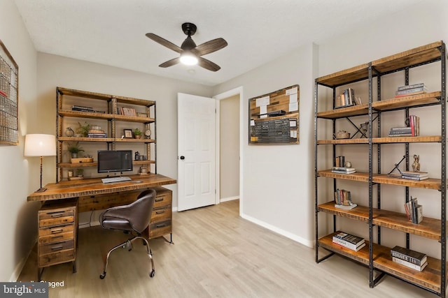 home office featuring a ceiling fan, baseboards, and light wood finished floors