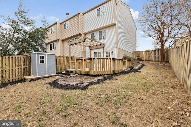 rear view of property with a pergola, a fenced backyard, a storage shed, an outdoor structure, and a wooden deck