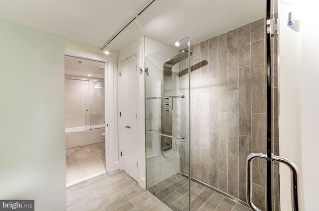 bathroom featuring track lighting, toilet, and wood tiled floor