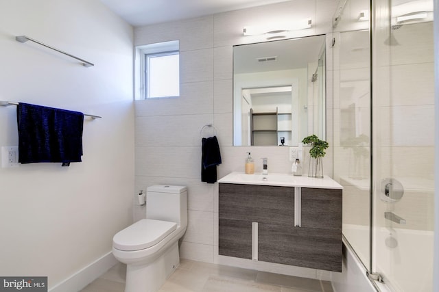 full bath with visible vents, bath / shower combo with glass door, toilet, tile patterned floors, and vanity