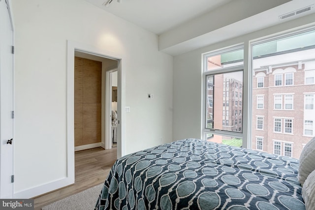 bedroom featuring wood finished floors, visible vents, and baseboards