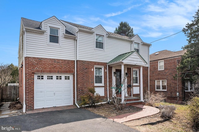 view of front of property featuring brick siding, an attached garage, and aphalt driveway