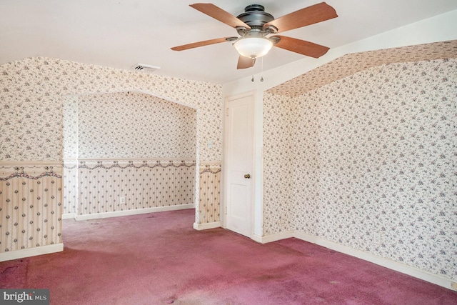 carpeted spare room with baseboards, visible vents, wallpapered walls, and a ceiling fan