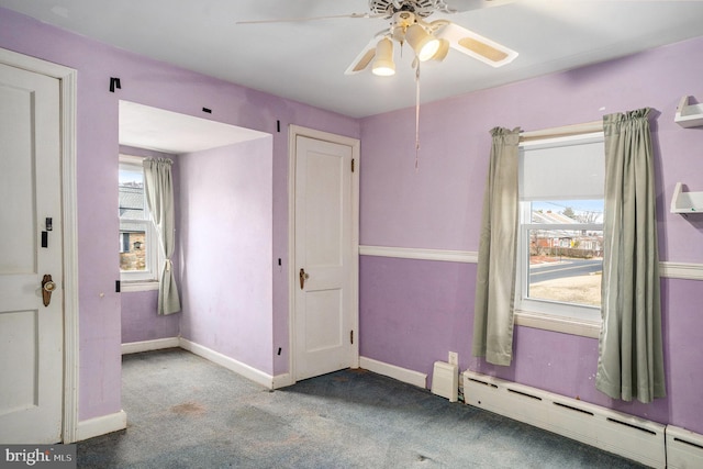 carpeted empty room with baseboard heating, baseboards, and ceiling fan