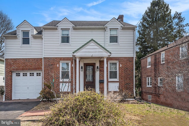 view of front of home with brick siding, a chimney, an attached garage, and a shingled roof