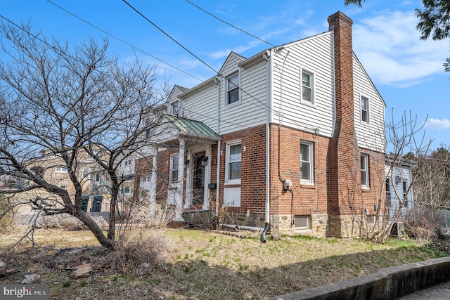 view of side of home featuring brick siding and a chimney