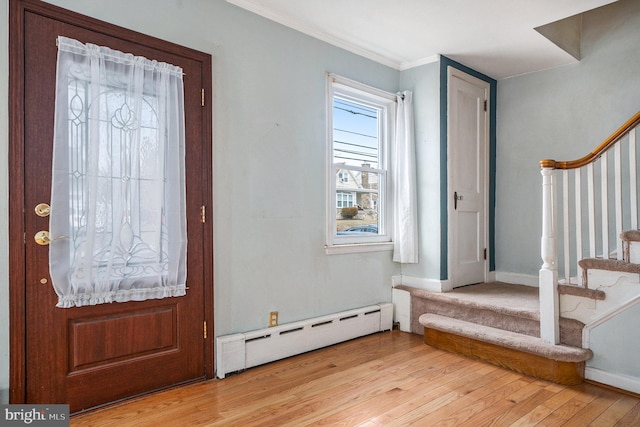 entrance foyer featuring stairway, baseboards, light wood finished floors, a baseboard heating unit, and crown molding