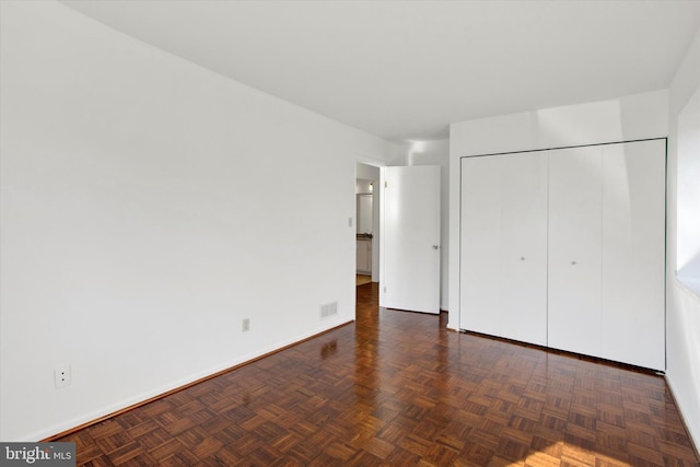 unfurnished bedroom featuring a closet, visible vents, and baseboards