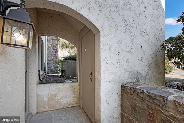 property entrance with central air condition unit and stucco siding