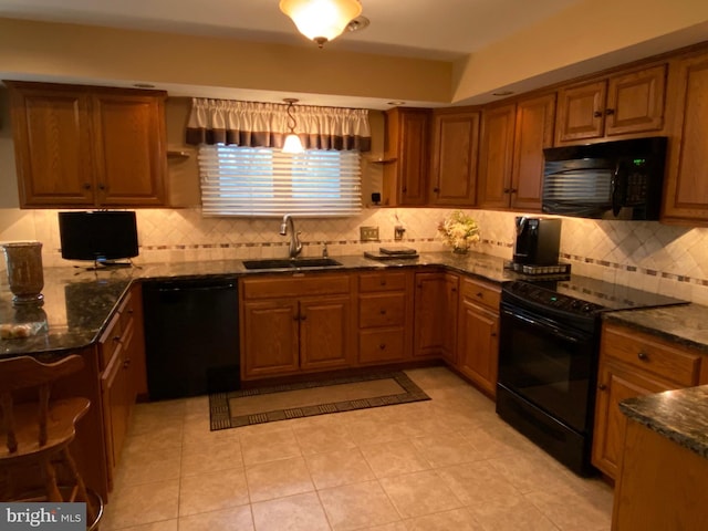 kitchen with dark stone counters, brown cabinets, black appliances, open shelves, and a sink