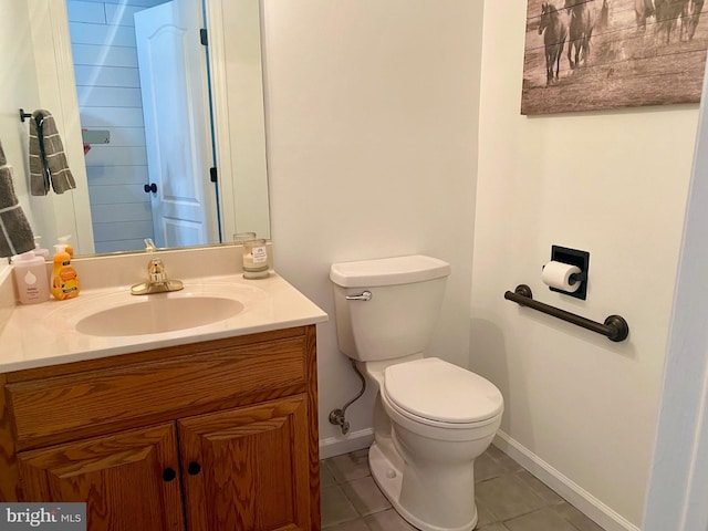 bathroom featuring toilet, vanity, baseboards, and tile patterned floors