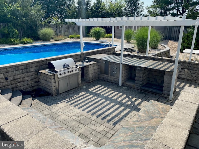 view of pool featuring a fenced in pool, grilling area, an outdoor kitchen, a patio area, and fence